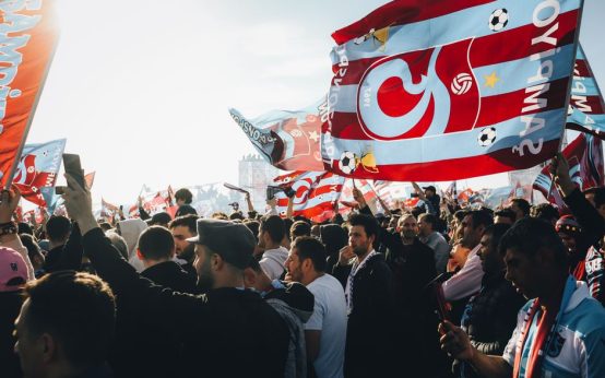 Aficionados al fútbol viendo un partido en una pantalla pública