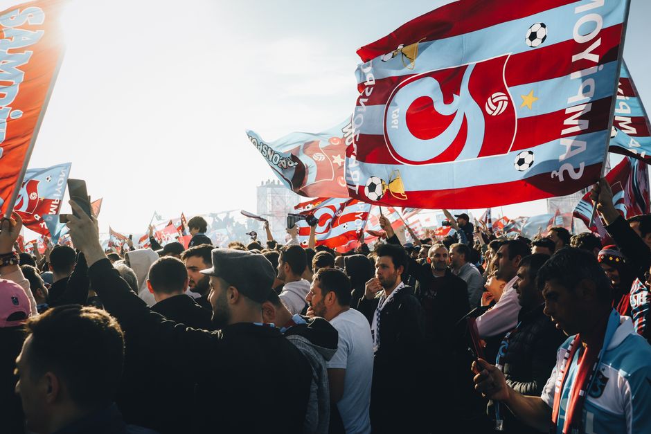 Aficionados al fútbol viendo un partido en una pantalla pública