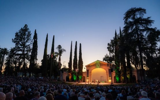Representación teatral al aire libre en un parque durante el atardecer