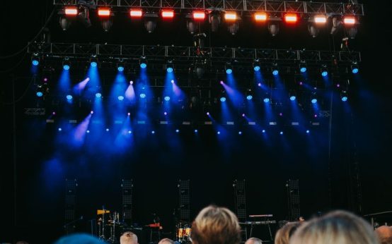 Público asistiendo a un concierto nocturno en un gran escenario al aire libre