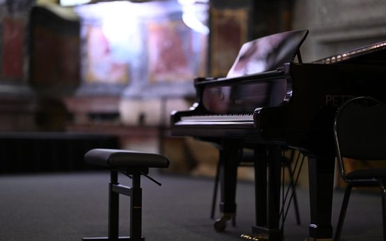 Piano de cola en sala de conciertos preparado para una actuación