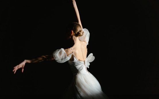 Bailarines en una representación de danza clásica sobre un escenario iluminado
