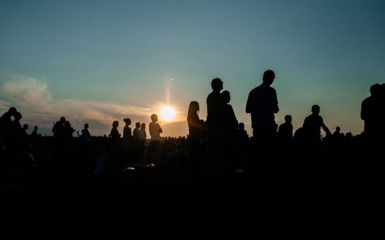 Personas reunidas al aire libre para observar un fenómeno astronómico