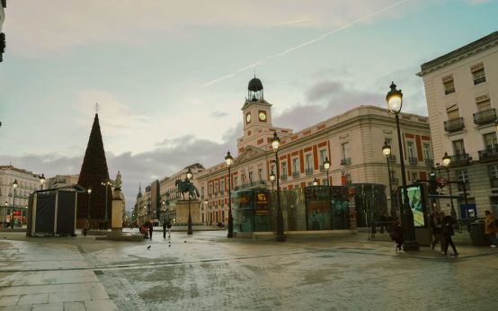 Plaza de pueblo española iluminada durante una celebración festiva nocturna