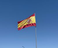 Bandera de la Comunidad de Madrid ondeando con sus siete estrellas blancas sobre fondo rojo carmesí