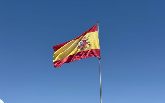 Bandera de la Comunidad de Madrid ondeando con sus siete estrellas blancas sobre fondo rojo carmesí