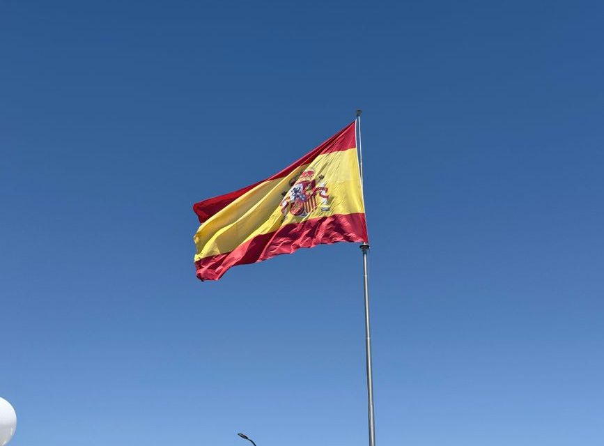 Bandera de la Comunidad de Madrid ondeando con sus siete estrellas blancas sobre fondo rojo carmesí